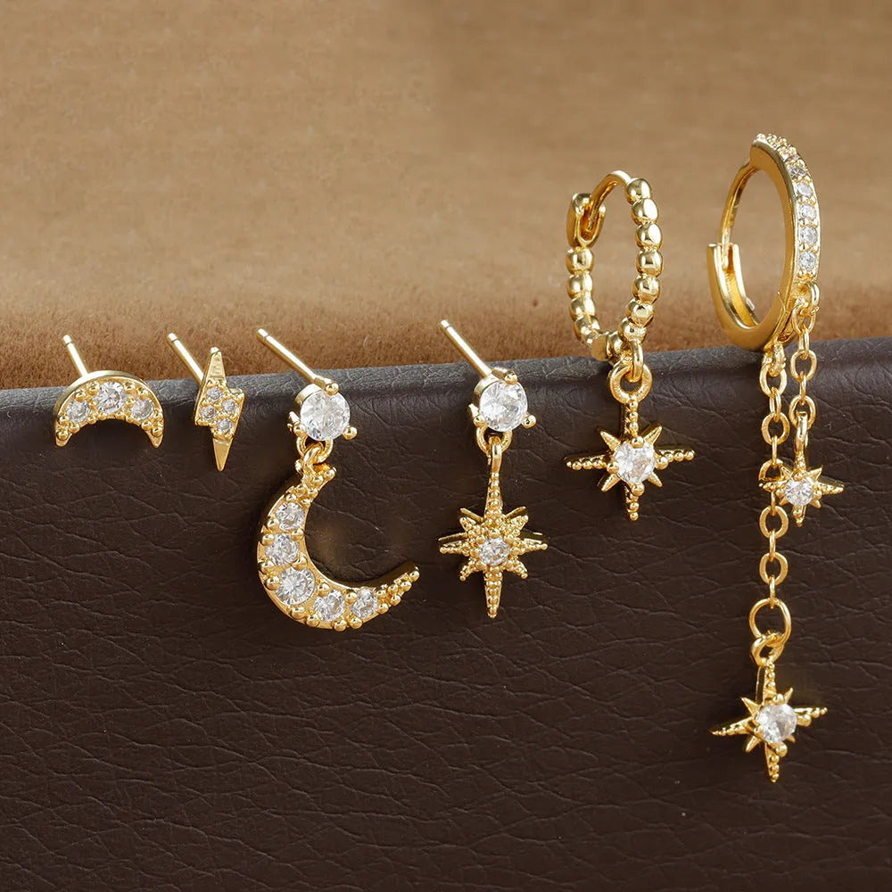 Six pairs of gold chain tassel earrings with zircon studs displayed together