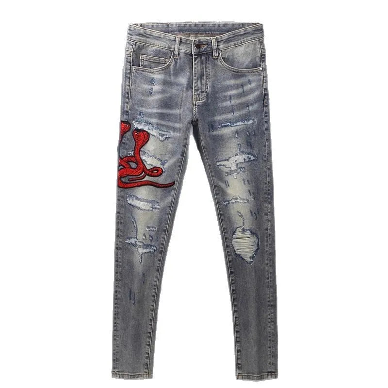 Slim fit jeans with a washed-out old colour finish, hole patches, and embroidery detail on the legs.