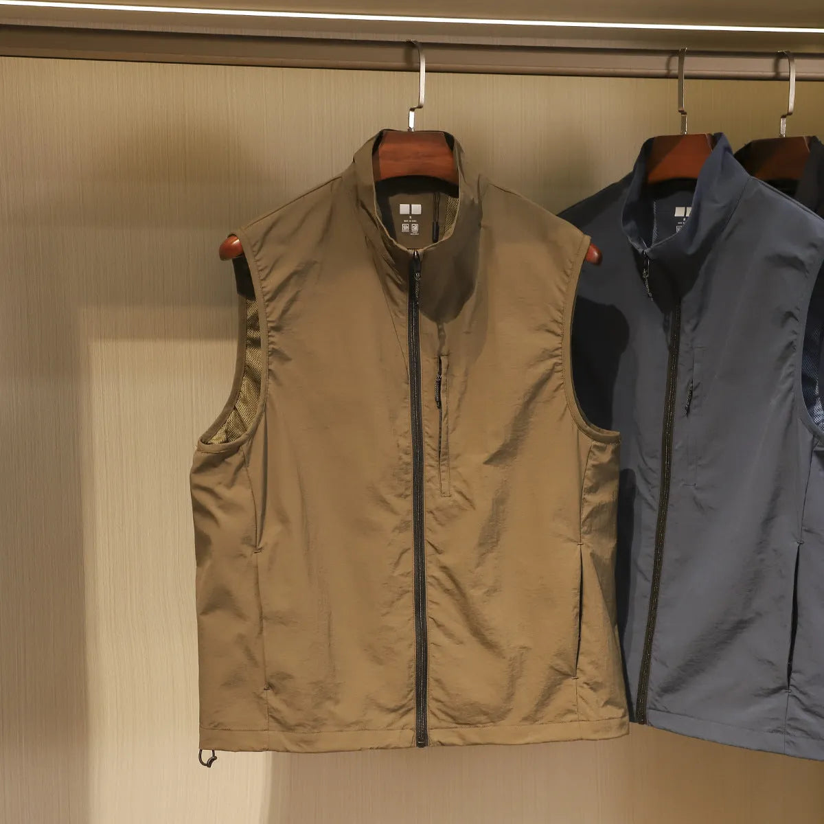 Men's straight cut nylon vest in army green with side seam pockets.
