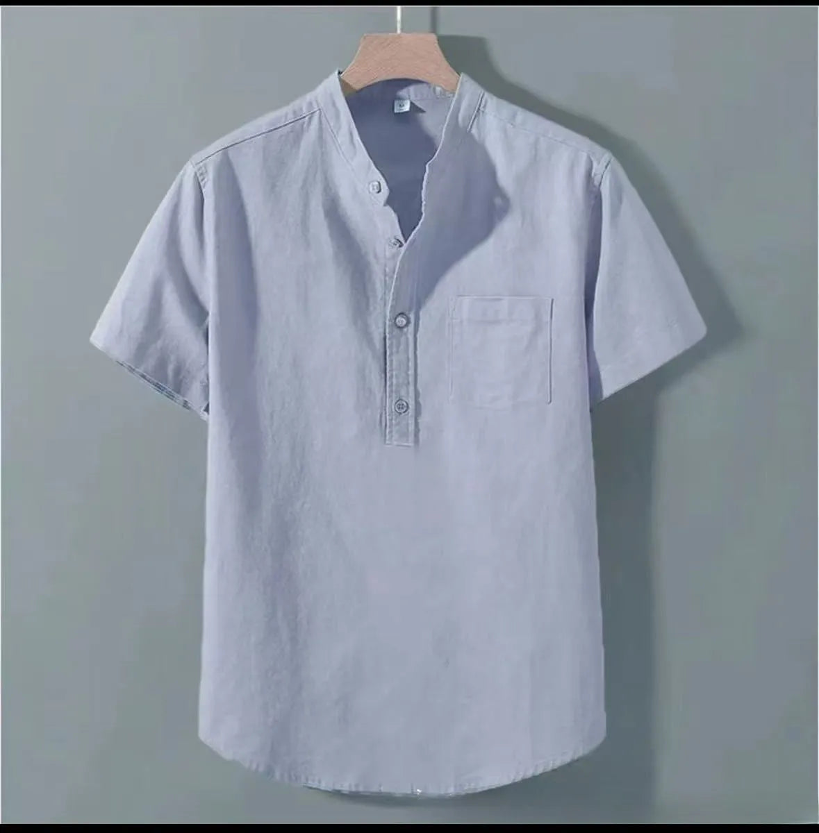 Man wearing a beige slub linen casual shirt with a stand collar and short sleeves, loose fit.