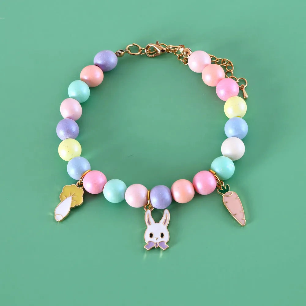 Macaron-coloured resin pet collar and bracelet set for birthday photoshoots on a neutral background.