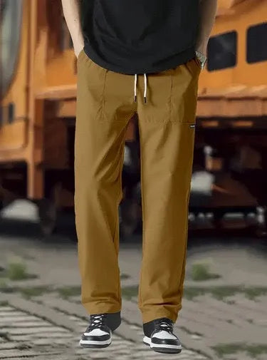 Men's polyester trousers in light grey, shown laid flat, suitable for spring and autumn wear.