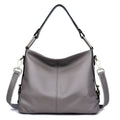 Genuine leather vertical square crossbody bag in black showing outer pocket and structured shape.