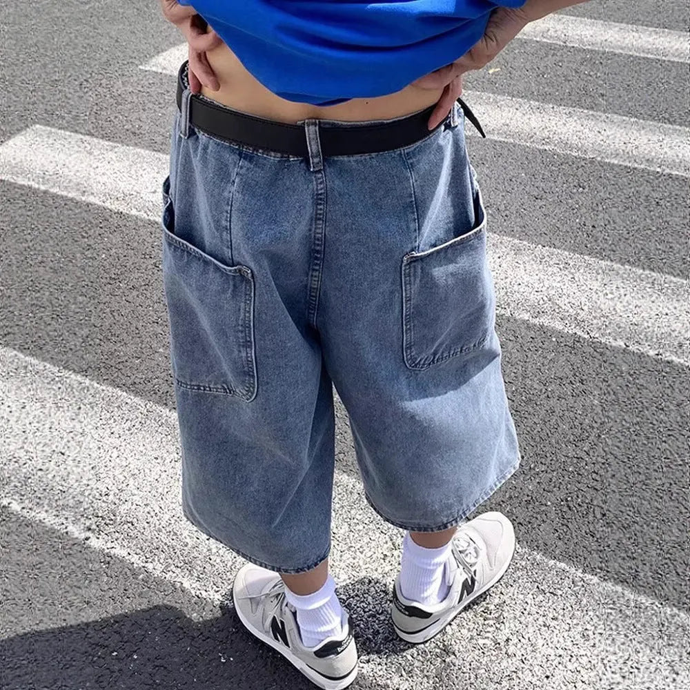 Man wearing blue washed denim pirate-style shorts with cropped length and high waist.
