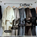 Women's beige knitted cardigan three-piece set with sleeveless vest and suspender trousers on a hanger.