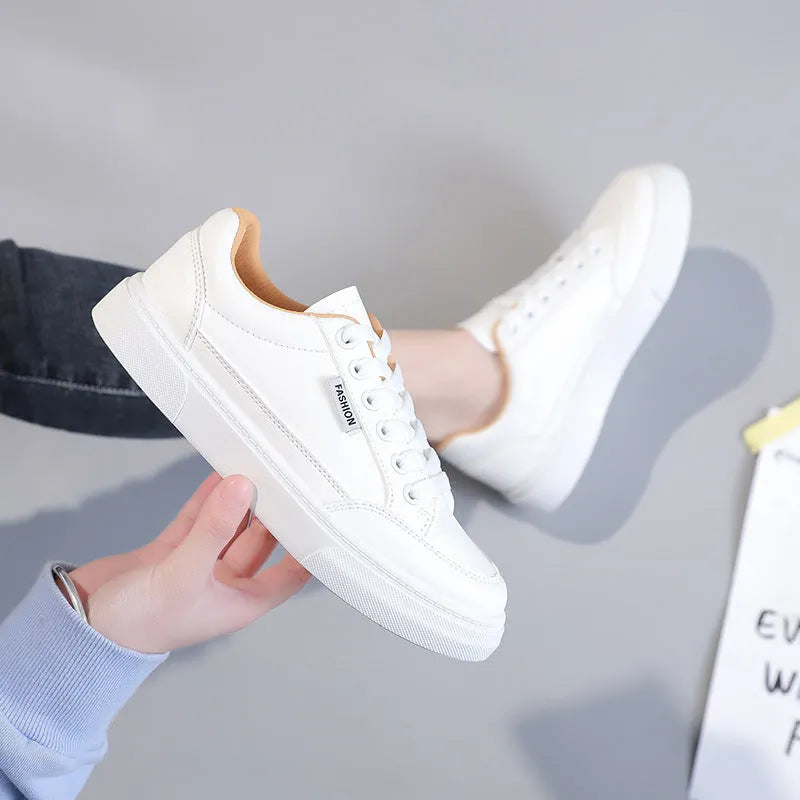 Women's brown and white Korean-style low-top sneakers with artificial PU uppers on solid background.
