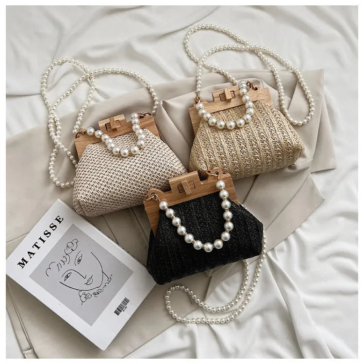 Women's straw woven shoulder bag with pearl chain detail showing internal organisation compartments