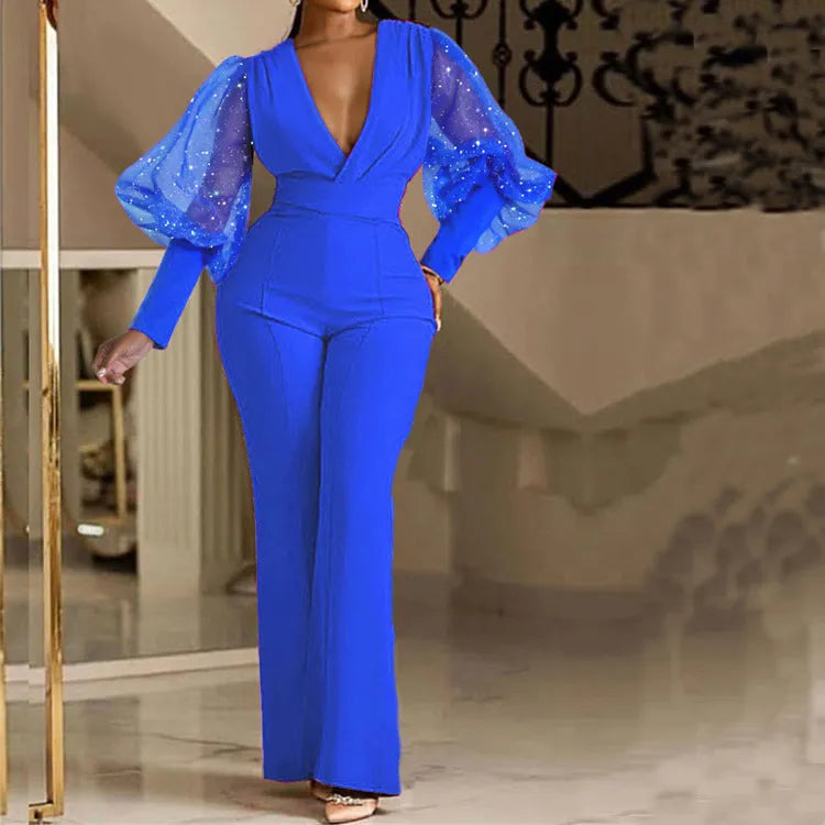 Red women's jumpsuit with mesh stitching on the torso, long sleeves, elastic waist, and wide-leg trousers.