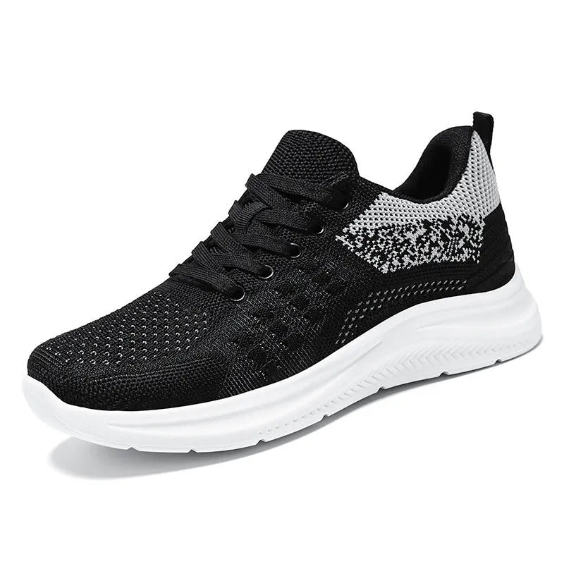 Women's low-top black mesh sneakers with round toe and white PVC sole, shown with lace-up front.