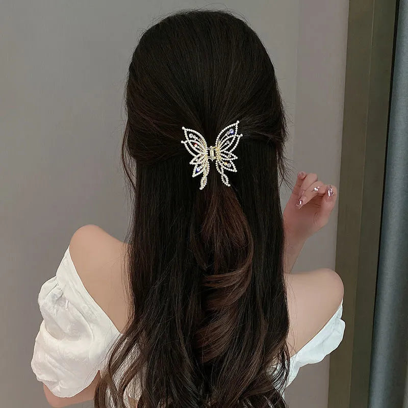 Elegant butterfly-shaped alloy hair clip for women, shown in rhinestone and pearl style options.