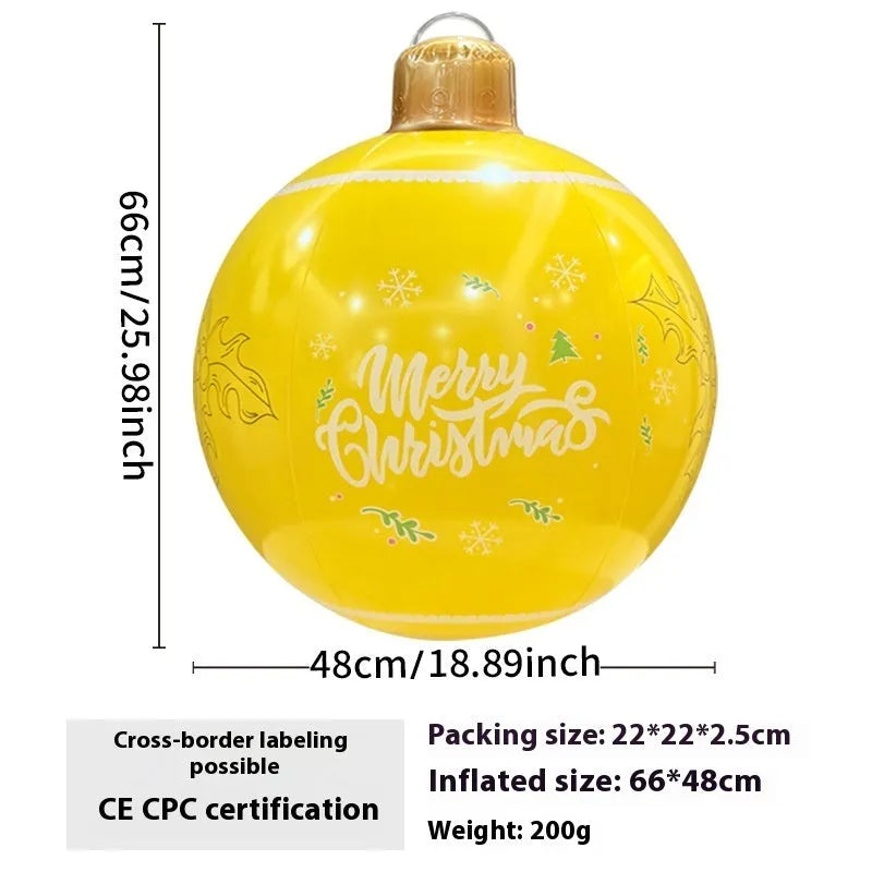 Large red inflatable Christmas ball with snowflake pattern and flash light, shown with a hand pump in a garden setting.