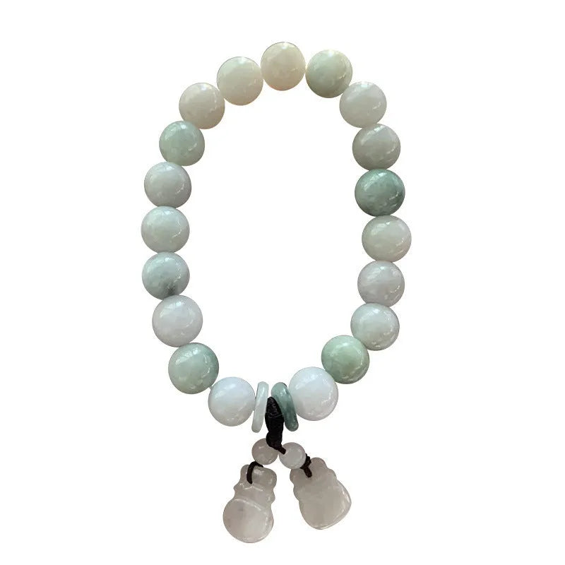 Natural green jade bracelet with a geometric pendant charm on a wrist.