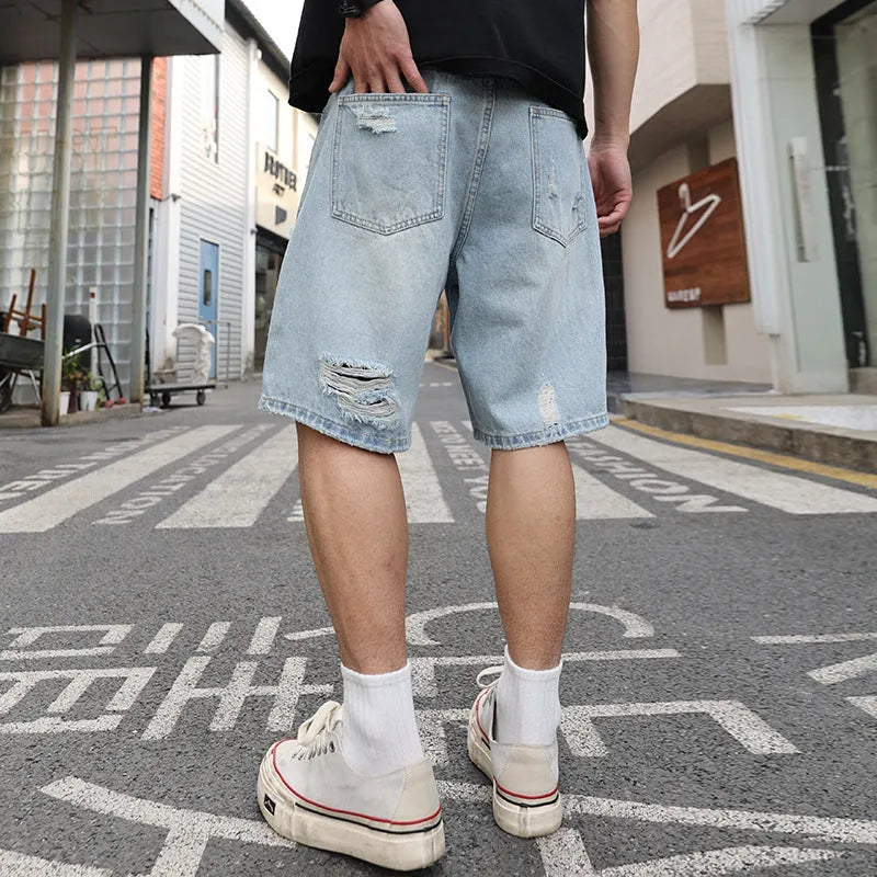 Light blue ripped denim shorts with a loose, straight leg fit and distressed detailing.