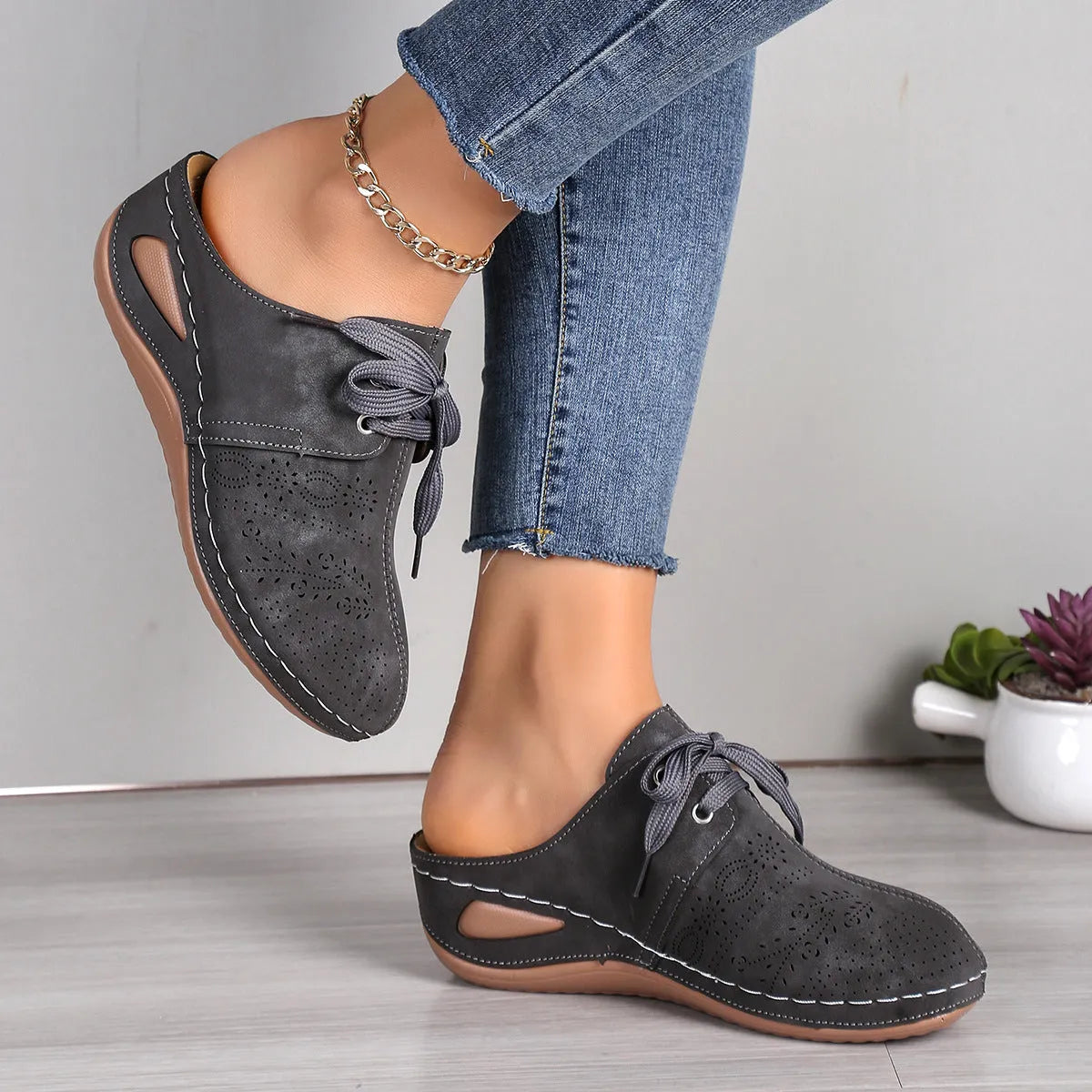 Women's black suede lace-up wedge slippers with a baotou toe and hollow out heel on a rubber sole.