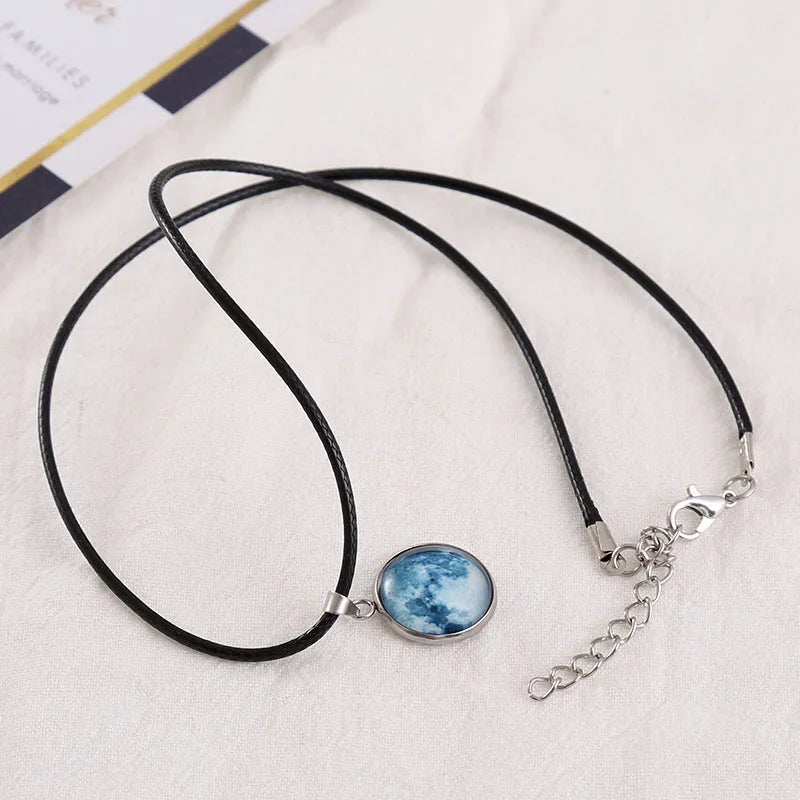 Luminous alloy and organic glass constellation pendant necklace with adjustable chain on white background.