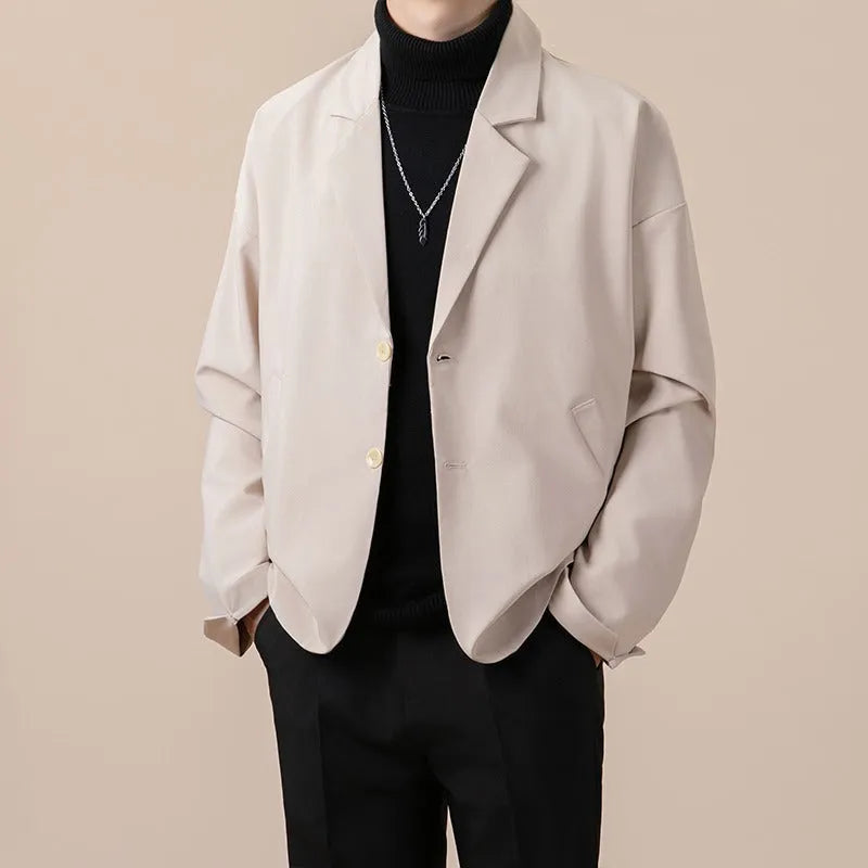 A man wearing a loose-fit casual suit jacket in a light colour, suitable for smart-casual occasions.