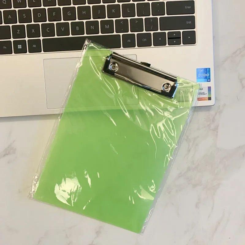 A4 transparent plastic writing board pad with metal clip in blue colour on a desk