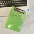 A4 transparent plastic writing board pad with metal clip in blue colour on a desk