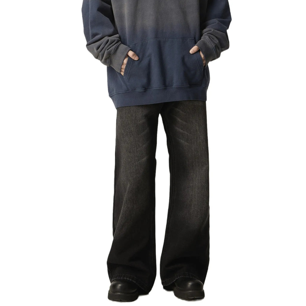 Man wearing black loose-fit straight-leg retro jeans in a casual setting.