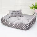 Polka dot print square dog bed with raised sides and a matching embroidered pillow in grey.