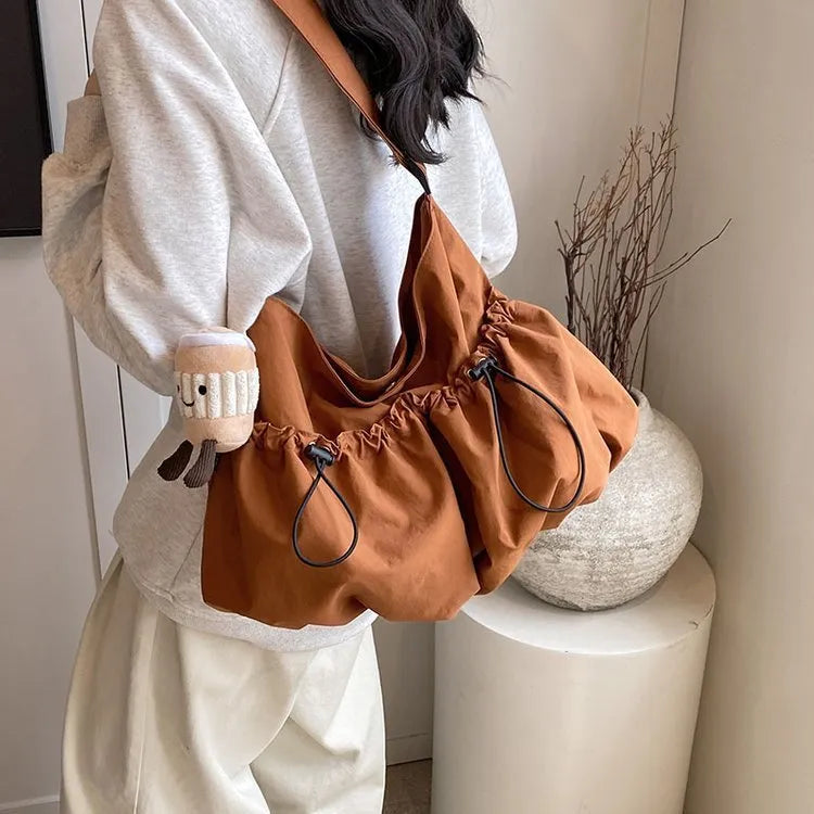 Ultra-light pleated foldable crossbody bag in soft polyester fabric, shown in green with split pockets.