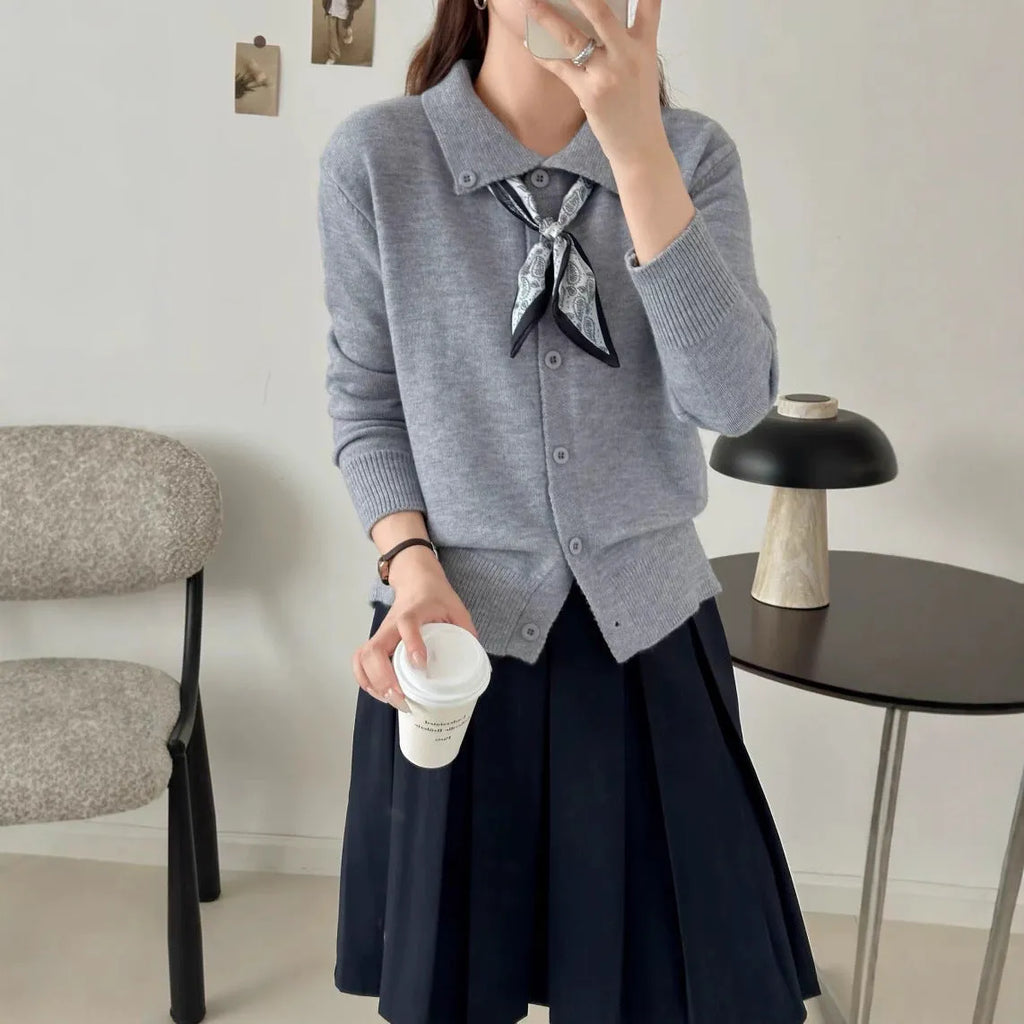 Beige cardigan sweater with a built-in lapel scarf and long sleeves laid flat