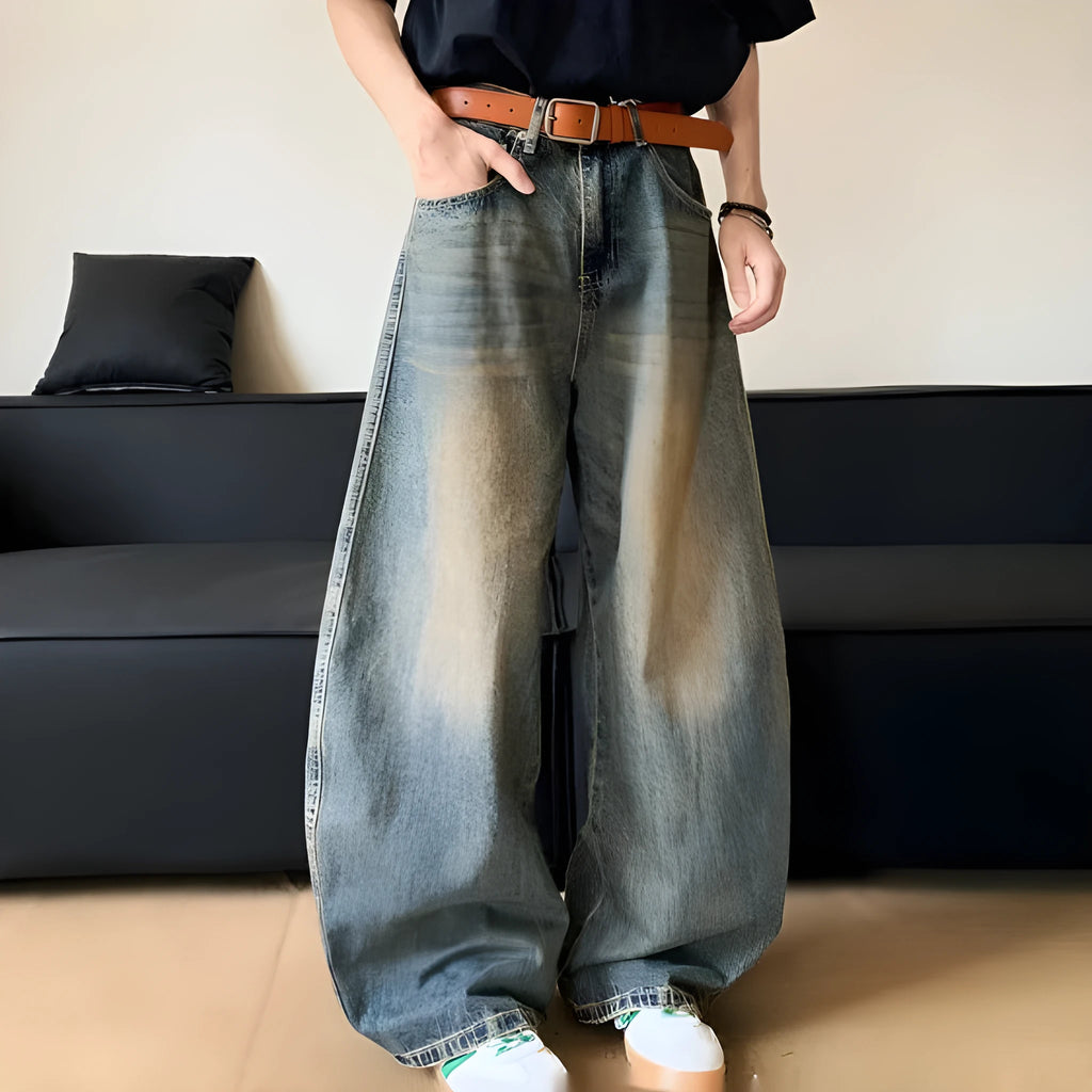 Man wearing retro blue distressed denim jeans with a slim-fit wide-leg cut.
