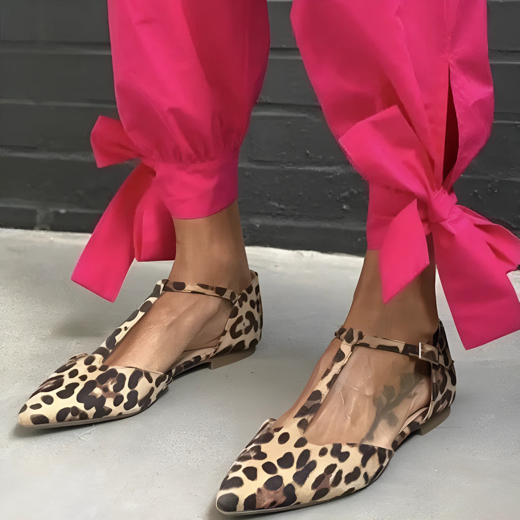 Leopard print women's pumps with a low chunky heel, pointed toe, and cross ankle straps.