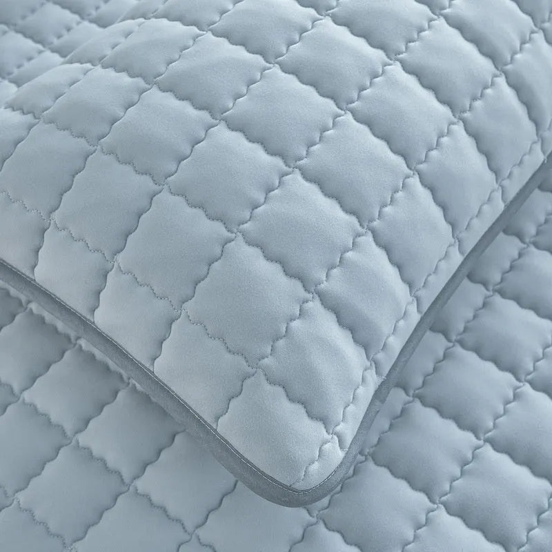 A washed cotton waterproof fitted sheet in a neutral colour, shown fitted neatly on a mattress corner.