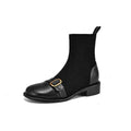 Black women's low heel Martin boot with belt buckle stitching and lace-up front on a rubber sole.