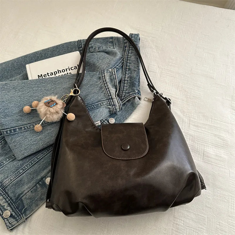 Women's textured PU leather shoulder bag with single strap and mobile phone compartment in black colour