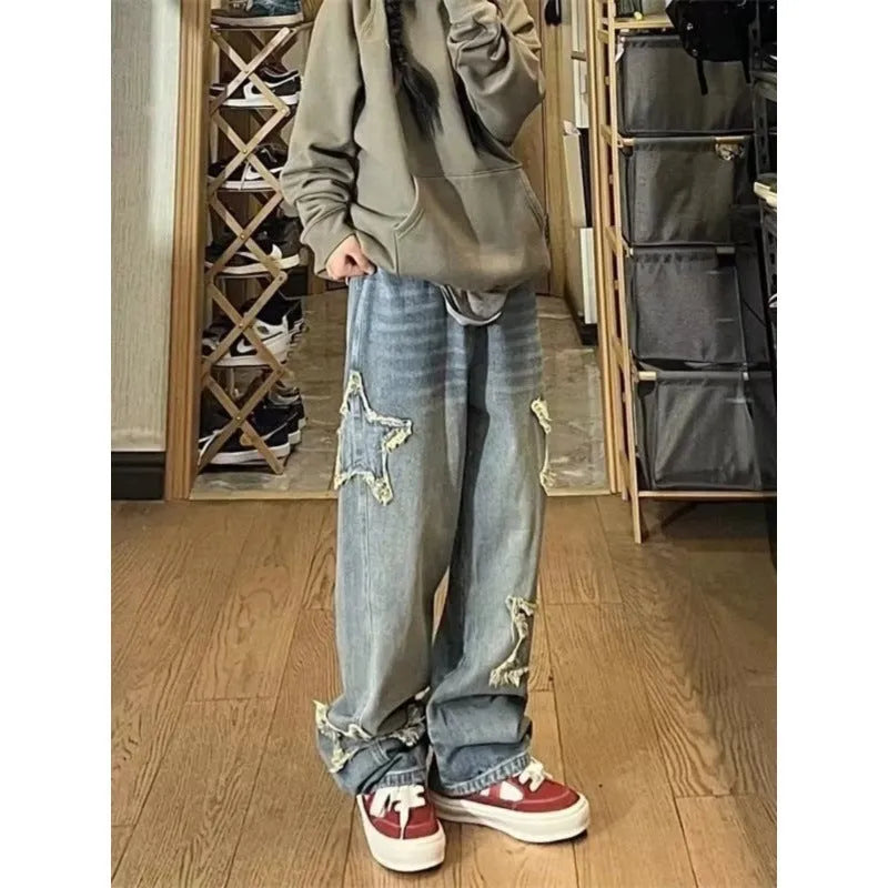 Blue high-waisted women's wide-leg denim trousers laid flat, showing straight-leg cut and front details.