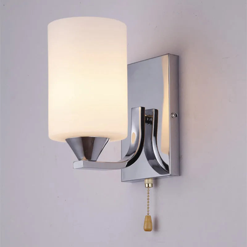 Modern chrome wall lamp with glass lampshade in single head configuration on white wall