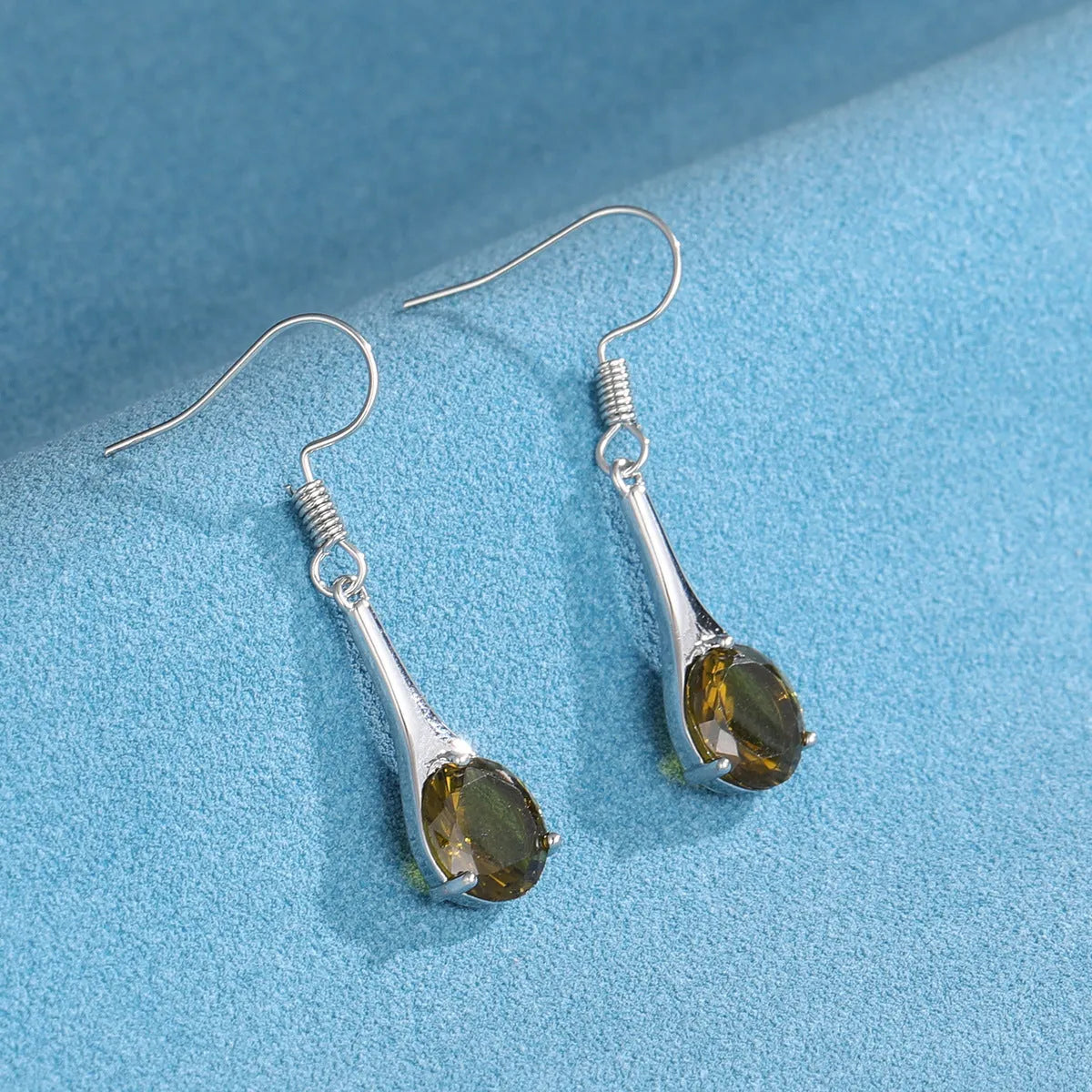 Olive green topaz coloured drop earrings with a water drop shape and minimalist retro design.