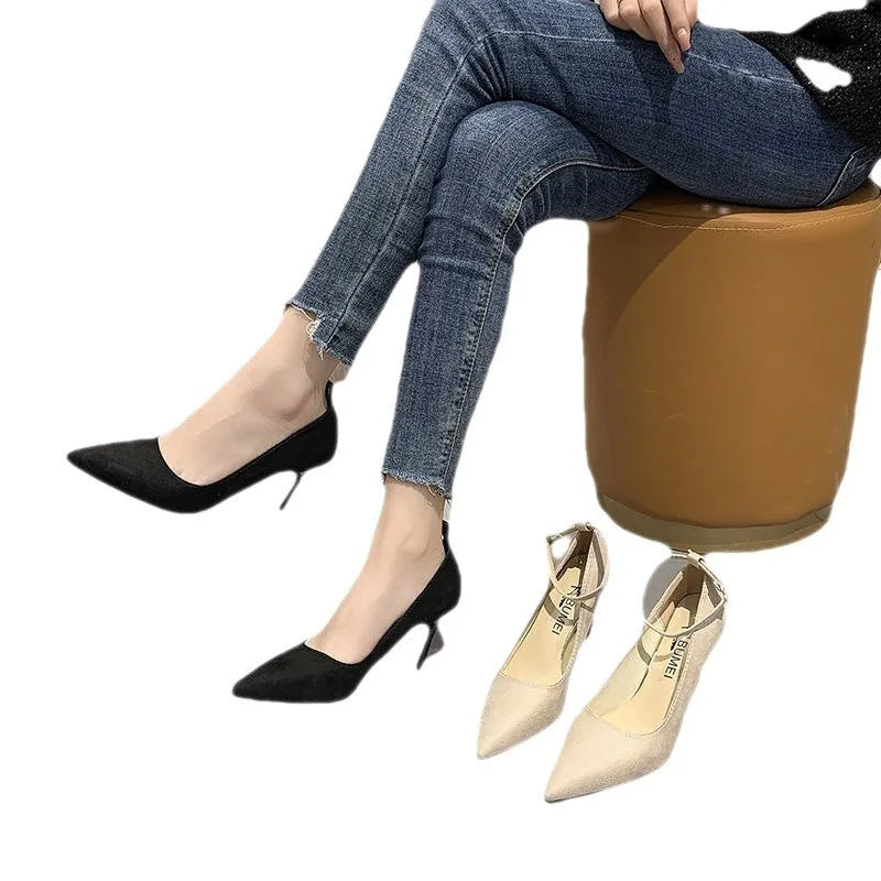 Women's black stiletto pump with ankle buckle detail and a rubber sole.