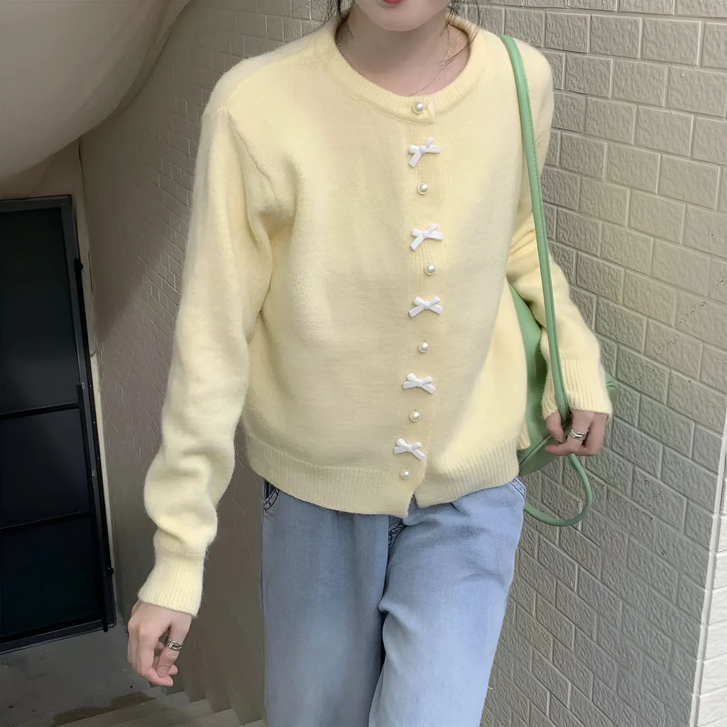 Women's solid colour cardigan sweater with pearl buttons in a light blue shade, shown open.