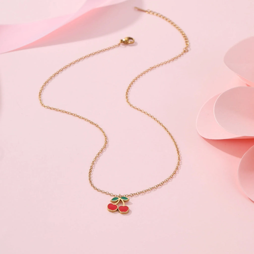 Cherry jewellery set showing necklace, bracelet, earrings and ring with geometric fruit designs on stainless steel chains