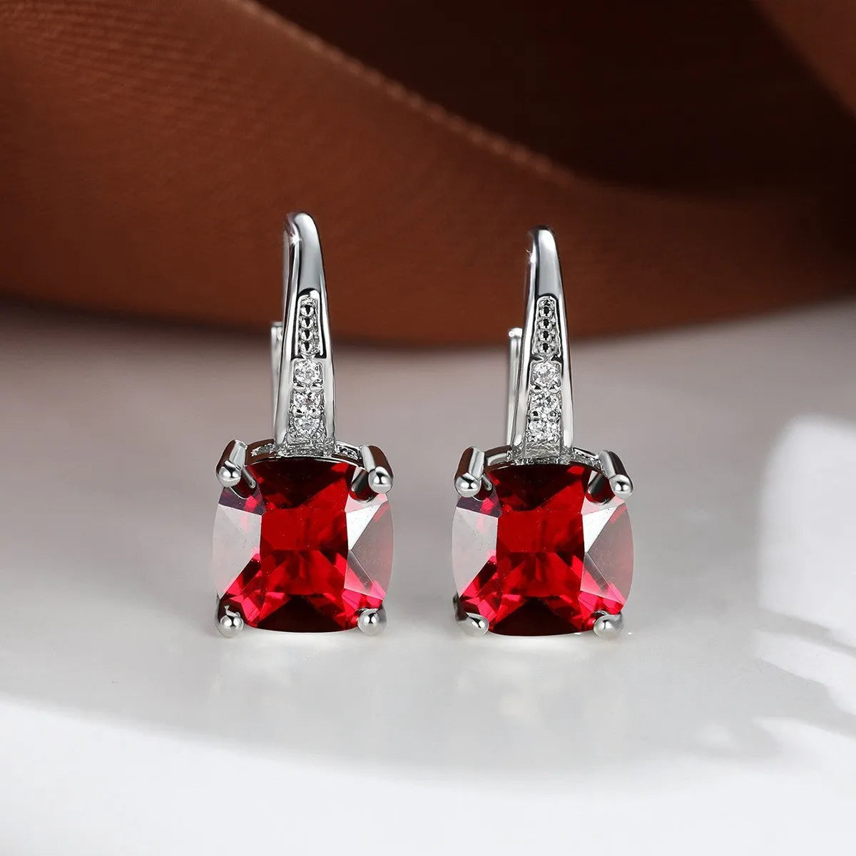 Square geometric ear hook earrings with zircon stones in an electroplated copper setting.