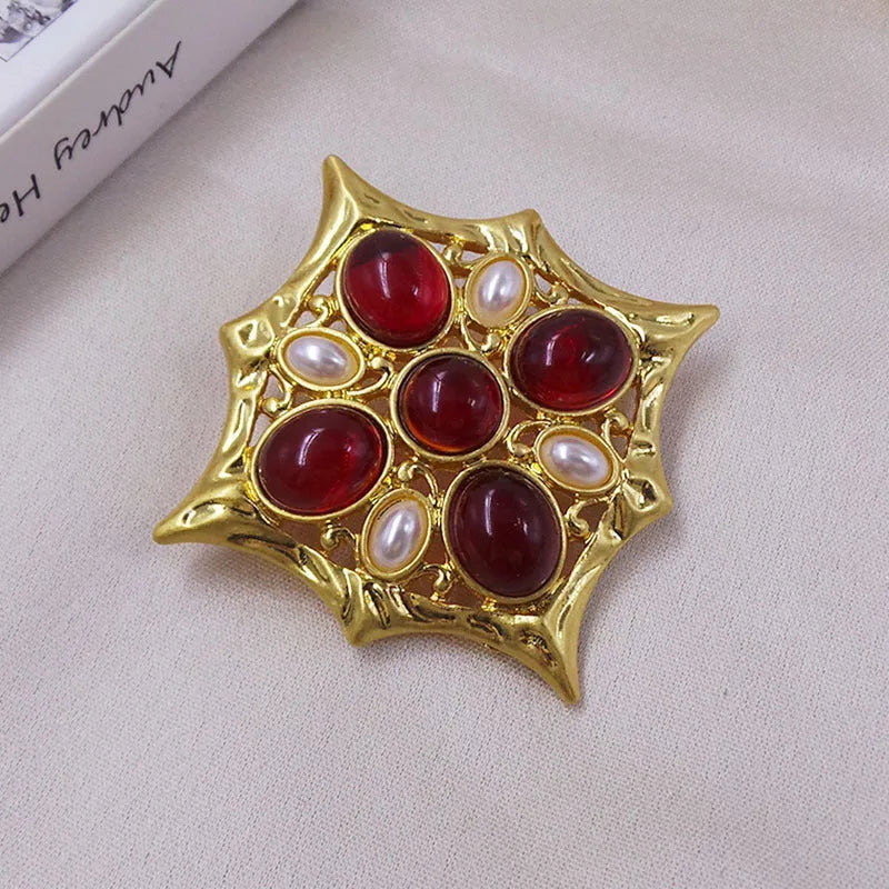 A vintage-style zinc alloy brooch with a baroque cross design and crystal accents.