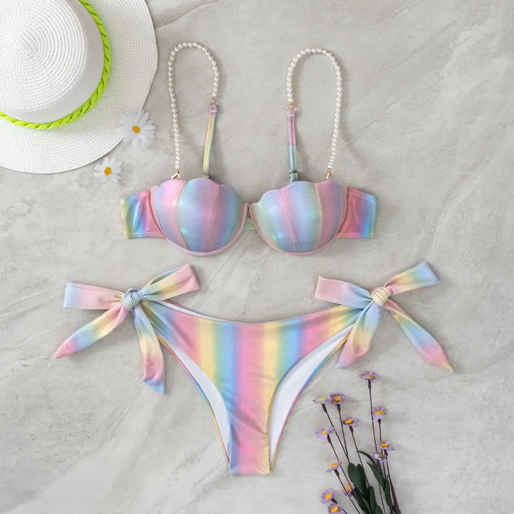 Women's shell rainbow patterned bikini swimsuit with a split tied front, on a mannequin.