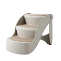 Foldable grey plastic pet stairs for small dogs and cats next to a sofa, with a non-slip mat visible.
