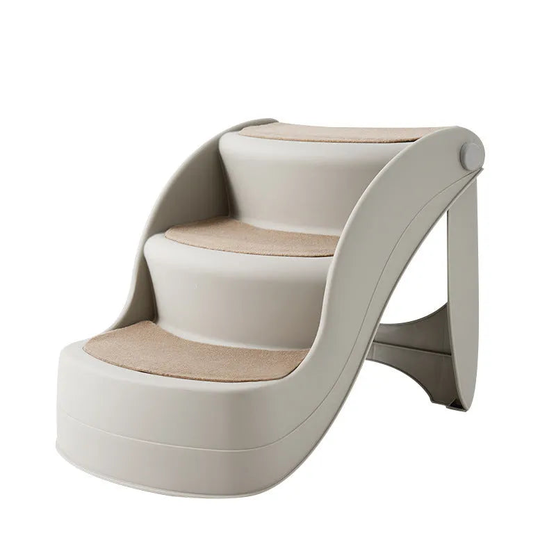 Foldable grey plastic pet stairs for small dogs and cats next to a sofa, with a non-slip mat visible.