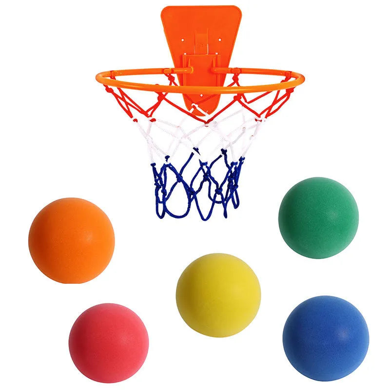 Silent high density foam sports ball in assorted bright colours next to a basketball frame.