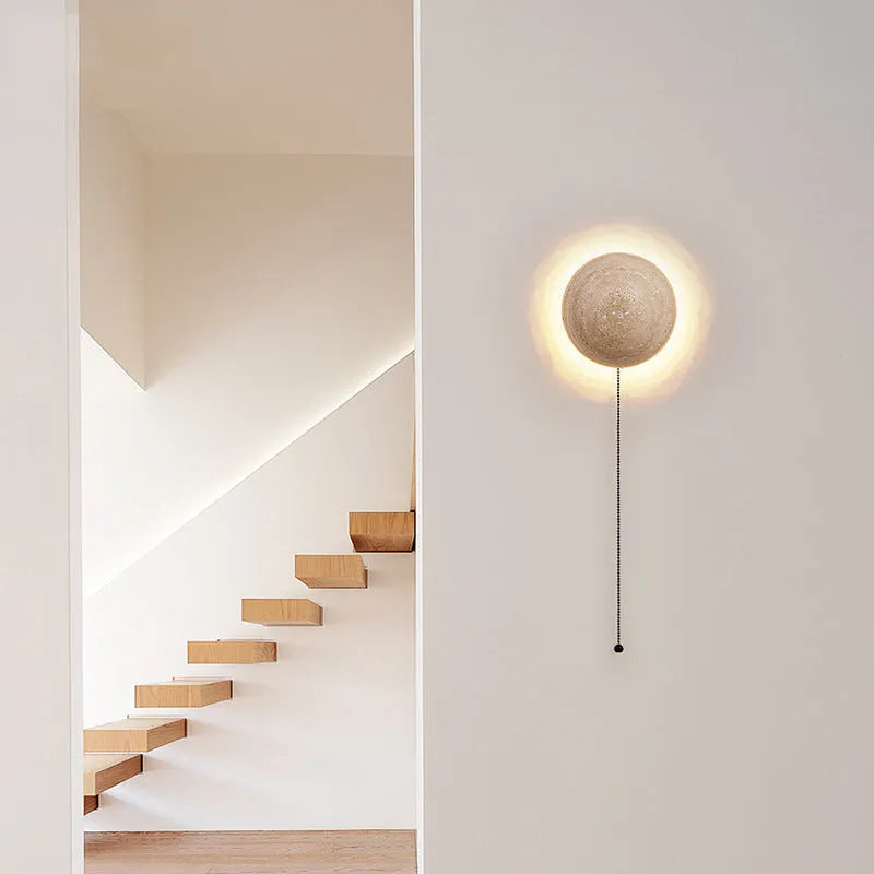 Vintage semicircle wall lamp with yellow cave stone shade and black iron frame mounted on a wall.