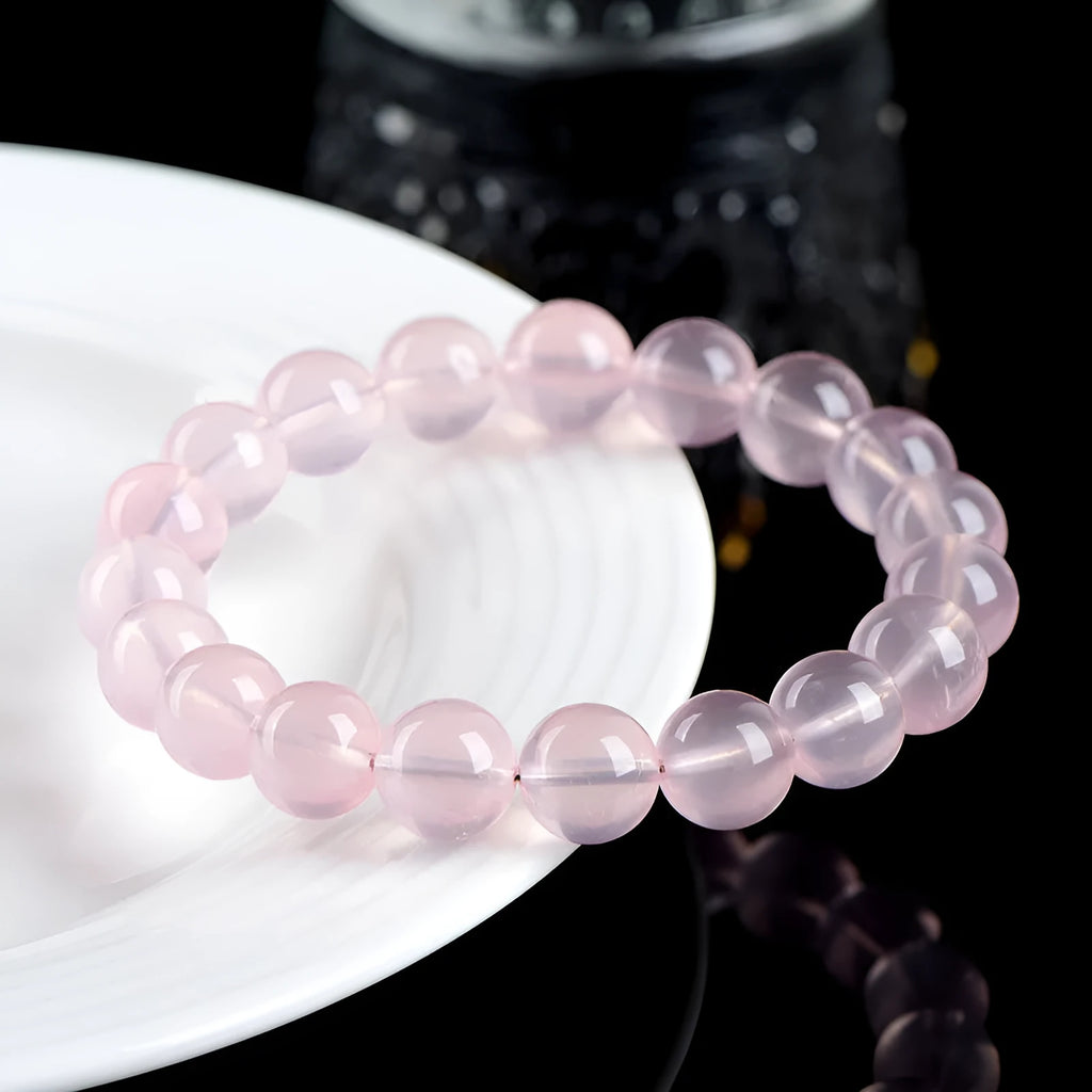 Women's natural style bracelet with round polished crystal beads in pink, showing size options from small to large beads.