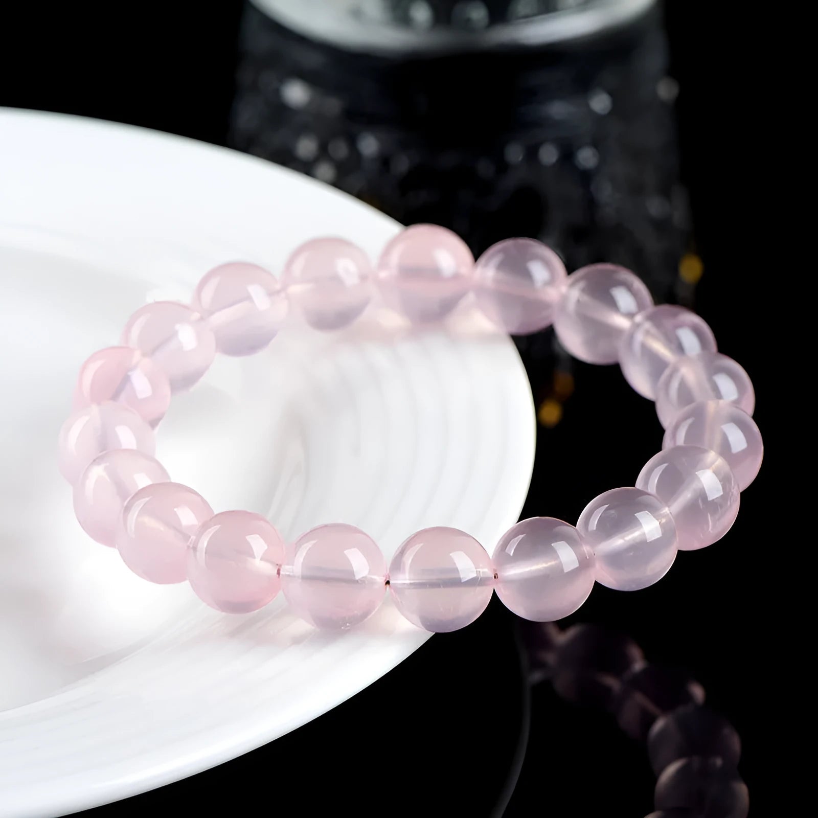 Women's natural style bracelet with round polished crystal beads in pink, showing size options from small to large beads.