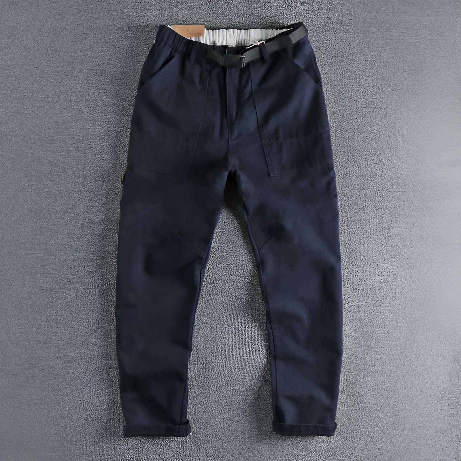 Men's khaki cotton work trousers with N buckle belt on a mid waist, showing three-dimensional cut.