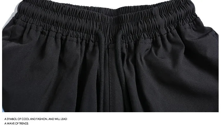 Man wearing loose black quick-drying sports shorts with an elastic waist for training.