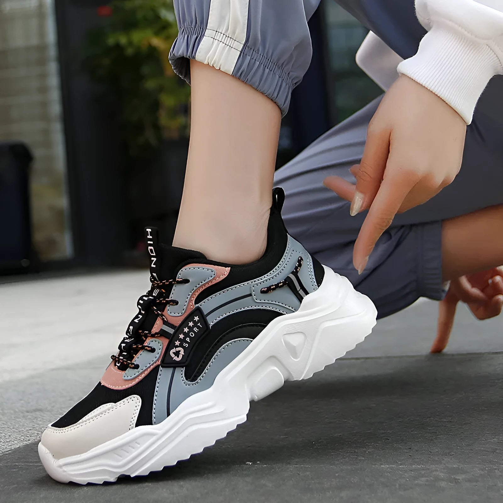 Women's white thick-soled casual sports shoes with mesh upper and buckle detail.