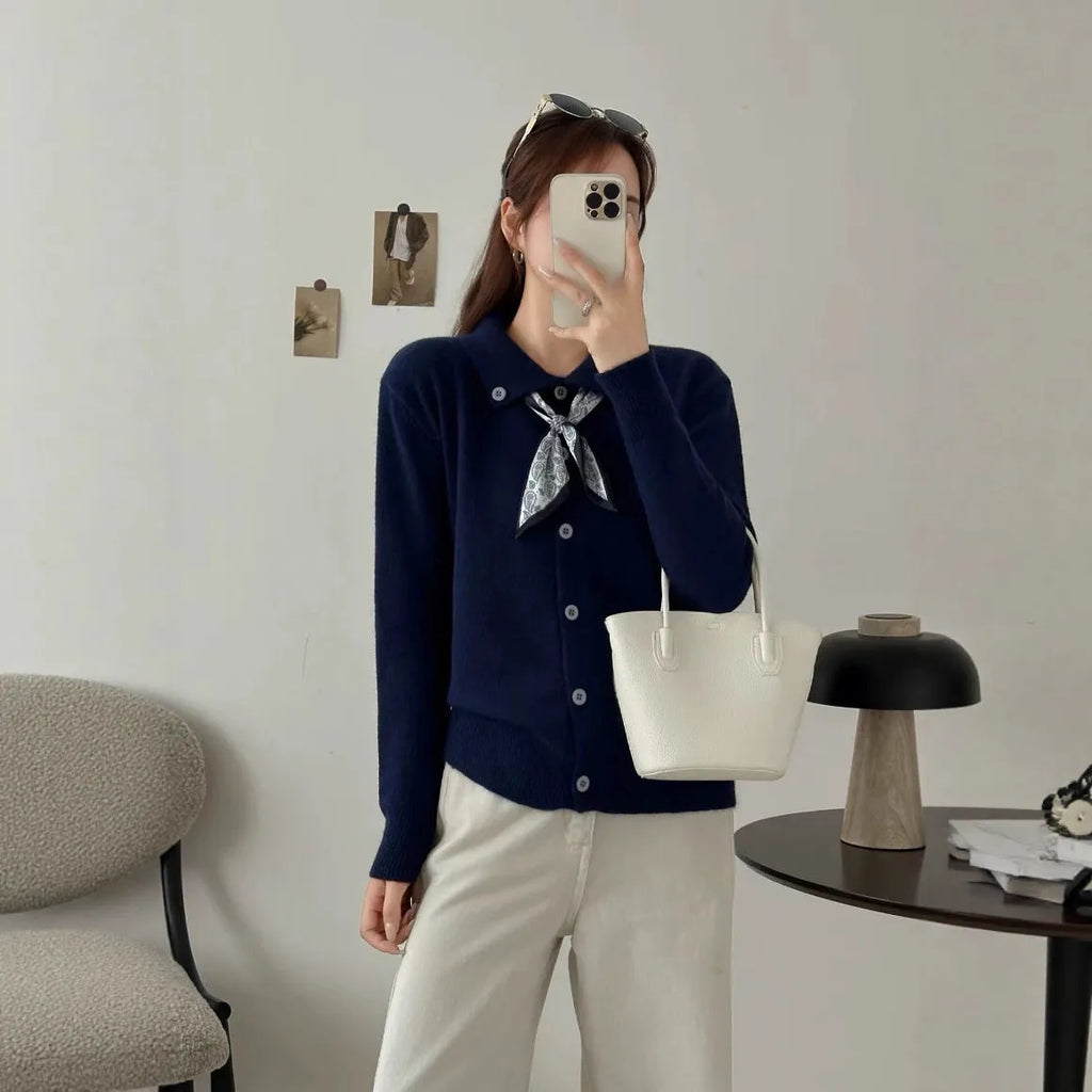 Beige cardigan sweater with a built-in lapel scarf and long sleeves laid flat